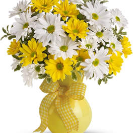 Yellow and white daisy bouquet in a yellow vase with a gingham ribbon