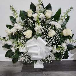 White rose and chrysanthemum arrangement with a large white bow