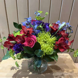Colorful bouquet in a clear glass vase with roses, chrysanthemums, and alstroemeria