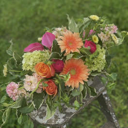 Mixed bouquet with orange gerbera daisies, roses, and pink blooms