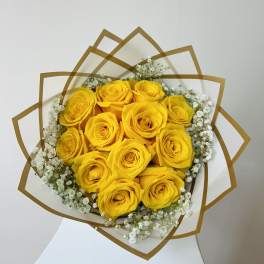Bouquet of yellow roses with white baby's breath in decorative wrap