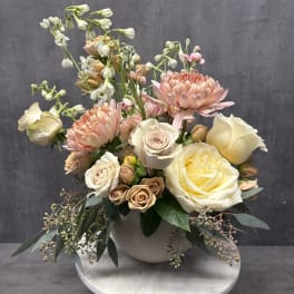 Pastel bouquet of roses and chrysanthemums in a white vase