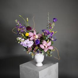 Mixed bouquet of pink and purple flowers in a white vase