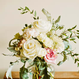 Bouquet of white and pink roses in a clear glass vase