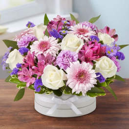 Pink and white mixed flower arrangement in a white hat box