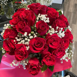 Bouquet of red roses with white baby's breath in pink wrap