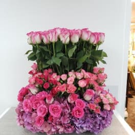 Large pink rose arrangement with hydrangeas on a table