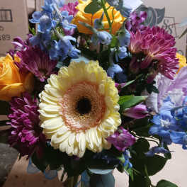Mixed bouquet with a large cream gerbera daisy and colorful blooms