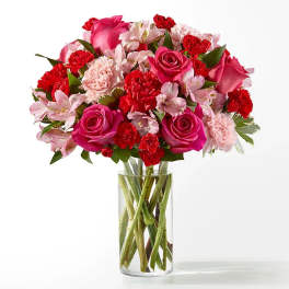 Bouquet of pink and red flowers in a clear glass vase