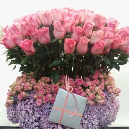 Large pink rose arrangement with a gift box and ribbon