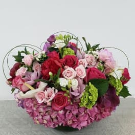 Large pink and red mixed flower arrangement with roses and hydrangeas