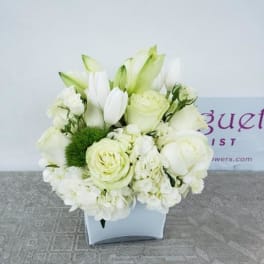 White floral arrangement in a square white vase