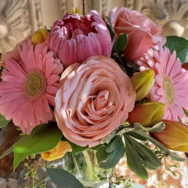 Pink mixed flower bouquet with roses, gerbera daisies, and tulips in a glass vase