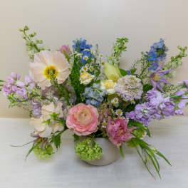 Pastel mixed flower arrangement in a low white vase