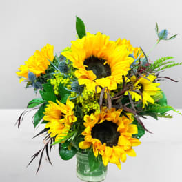 Bouquet of yellow sunflowers in a clear glass vase