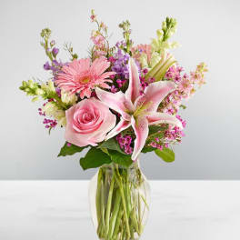 Pink rose and lily bouquet in a clear glass vase