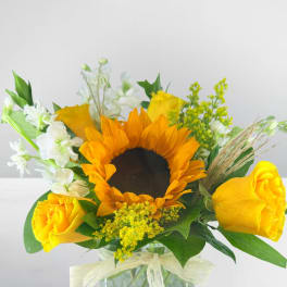 Sunflower and yellow rose bouquet in a glass vase
