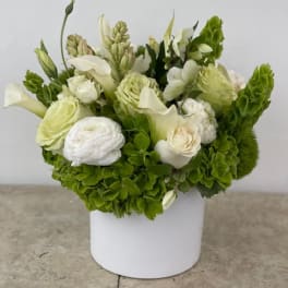 White and green floral arrangement in a white box