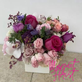 Bouquet of pink, purple, and white roses in a white box