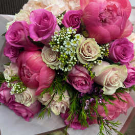 Bouquet of pink peonies and roses with small white filler flowers