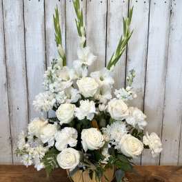 White roses and gladiolus in a pumpkin-shaped container