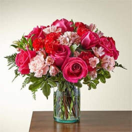 Pink roses and carnations in a clear glass vase