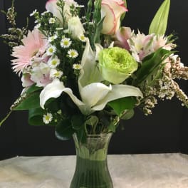 Mixed bouquet with pink and white flowers in a clear glass vase
