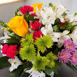 Mixed bouquet with yellow roses, white lilies, pink carnations, and green chrysanthemums