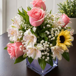 Pink roses and white alstroemeria in a square glass vase