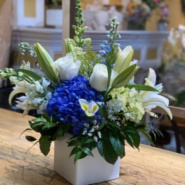 Blue hydrangea and white lilies in a white square vase