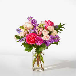 Bouquet of pink and purple roses in a clear glass vase