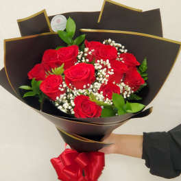 Bouquet of red roses with baby's breath in black wrap and a red ribbon