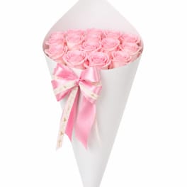 Bouquet of pink roses wrapped in white paper with a pink ribbon