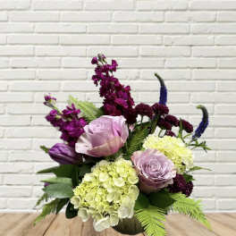 Mixed bouquet with lavender roses, hydrangeas, and purple blooms in a vase