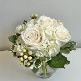 White rose and hydrangea bouquet in a clear glass vase
