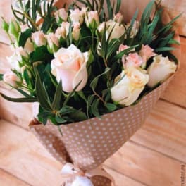 Bouquet of pale pink roses and small pink blooms in polka-dot wrap