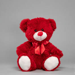 Red teddy bear with a satin bow on a gray background