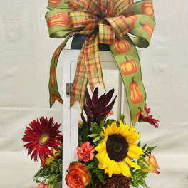 Fall floral arrangement with sunflowers, roses, and a pumpkin ribbon bow