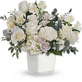 White rose arrangement in a clear square vase