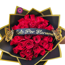 Bouquet of red roses wrapped in black and gold paper with a ribbon