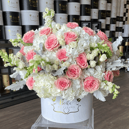 Large pink and white rose arrangement in a white hat box