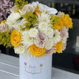 Bouquet of yellow, white, and blush roses in a white box