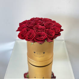 Red roses arranged in a gold round box