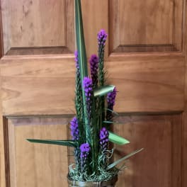 Tall purple floral arrangement in a woven basket