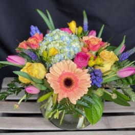 Mixed bouquet with a peach gerbera daisy in a glass vase