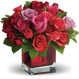 Mixed roses in a red glass vase