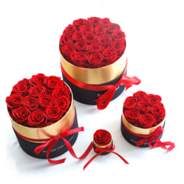 Red roses arranged in round gift boxes with red ribbons