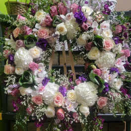 Large floral wreath with pink, white, and purple flowers on an easel