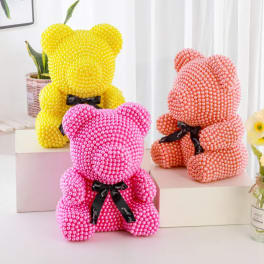 Three beaded teddy bears in pink, yellow, and peach