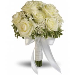 Hand-tied bouquet of ivory roses with white filler flowers and a white ribbon bow.